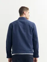Campera de estilo harrington color azul oscuro, con cierre frontal, cuello camisero y bolsillo frontal tipo parche.