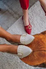 Zapato de cuero negro con taco cuadrado y faja de ojalillos.