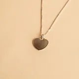 Conjunto de collar y dije en forma de corazón, fabricado en plata 925. El dije presenta una superficie lisa y brillante, ideal para personalizar con grabado, y se encuentra suspendido de una cadena de eslabones finos.