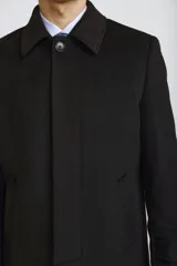 Abrigo tipo carcoat de corte clásico y estructura formal, en color azul marino. Presenta cierre frontal con botones, cuello camisero y bolsillos laterales. El interior cuenta con un forro oscuro con detalles en contraste.