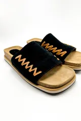 Sandalias bajas color marrón, con base de corcho y tira ancha de gamuza con pespuntes decorativos en hilo dorado.