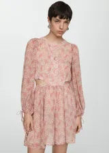Vestido corto de tejido fluido con estampado paisley en tonos rosados. Presenta cuello redondo con pequeña abertura frontal, mangas largas abullonadas con lazos en los puños y aberturas laterales en la cintura.