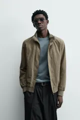 Cazadora azul marino de corte regular fit, confeccionada en tejido técnico repelente al agua. Presenta cuello subido, manga larga, bolsillos de vivo en cadera, bolsillo interior y acabados en rib en puños y bajo. Cierre frontal de cremallera oculta por solapa con botones a presión.