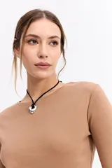 Remera de manga larga con cuello redondo y ajuste al cuerpo, confeccionada en tejido de algodón con textura acanalada.