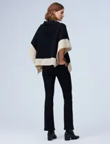 Poncho tejido colorblock, marrón y beige, con cuello vuelto asimétrico.