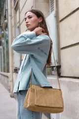 Bolso de hombro de piel color tostado con diseño acolchado y costuras geométricas. Cuenta con tres compartimentos, uno de ellos con cierre de cremallera, y solapa con cierre magnético. Incluye asa combinada de piel y cadena metálica dorada.