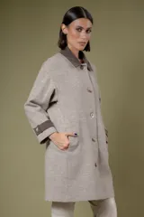 Tapado de corte recto con estampado de pata de gallo en tonos azul y gris. Presenta cuello camisero y detalles en los puños en color negro, cierre frontal con botones y bolsillos laterales.