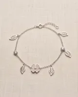 Pulsera de plata con cadena de eslabones, dije central de trébol de cuatro hojas con circonias pavé y dijes colgantes en forma de hoja.