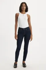 Jeans skinny de tiro medio color azul oscuro, ajustados en cadera y muslos, con cierre de bragueta.