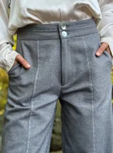 Pantalón gris de corte palazzo con cintura alta y detalle de costuras verticales en el frente.