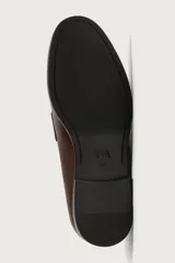 Mocasín de vestir para hombre, confeccionado en cuero marrón con diseño clásico de antifaz en el empeine, horma redonda y suela con ligero tacón.