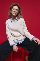 Sweater de tejido de punto negro con tramas de ochos en las mangas y laterales, cuello redondo a la base y mangas largas.