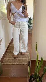 Pantalón de lino color crudo, de corte recto y pierna ancha, con cintura elastizada y cordón ajustable.