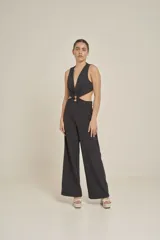 Mono largo negro con escote en V profundo, sin mangas y aberturas en la cintura unidas por un aro metálico.