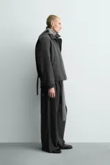 Pantalón de corte baggy fit, color gris oscuro con estampado de rayas verticales finas. Presenta cintura elástica con cordón interior, bolsillos frontales de vivo y bolsillos traseros de plastrón.