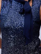 Blusa azul de microtul bordado con lentejuelas, marca Cable & Gauge. Cuello alto en gasa, escote asimétrico y lazo de ajuste.