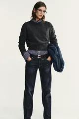 Jersey de punto con cuello redondo y manga larga, con acabados en rib ancho a tono y bajo asimétrico.