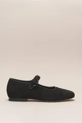 Zapato plano estilo Mary Jane de cuero negro, con punta fina y tira ajustable con hebilla sobre el empeine.