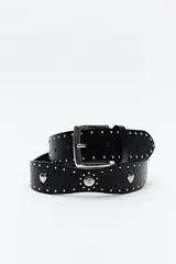 Cinturón negro de cuero sintético con hebilla metálica plateada y apliques de tachas plateadas con forma de corazón y circulares.