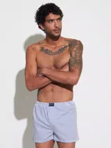 Bóxer de algodón blanco con estampado de flores pequeñas color celeste, con cintura elástica y logo de la marca en el centro.