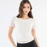 Camiseta de encaje blanco con textura de puntos, cuello redondo y mangas cortas con terminación ondulada.