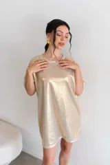 Remerón de viscosa color dorado con textura brillante y rayas verticales sutiles. Tiene un corte holgado y mangas cortas.