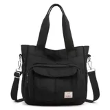 Cartera estilo tote color tostado, confeccionada en lona, con doble asa de mano, correa ajustable para el hombro y bolsillo frontal con cierre y etiqueta visible.