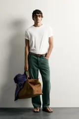 Jeans relaxed fit de algodón color verde oscuro, de tiro medio y pernera recta con raya de planchado. Cuenta con diseño de cinco bolsillos y cierre frontal con cremallera y botón.