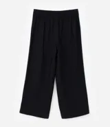 Pantalón negro de vestir, tiro alto, corte wide leg (pierna ancha), con bolsillos laterales y cierre frontal con cremallera y gancho.