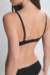 Conjunto de lencería compuesto por un corpiño con taza soft y aro, y una bombacha tipo vedetina. Ambas piezas presentan detalles de encaje en los bordes y están confeccionadas en un tejido suave y elástico.