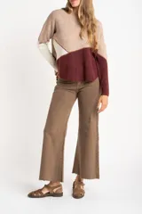 Sweater de tejido de punto con diseño de bloques de color en tonos beige, blanco roto y bordó. Presenta cuello redondo y mangas largas.