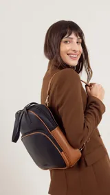 Mochila color bordó con doble asa superior, correas traseras regulables y bolsillo frontal con cierre. Se puede usar como mochila o como cartera.