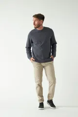 Remera de hombre negra de manga larga con puños, escote redondo y bolsillo en el pecho con etiqueta de marca.