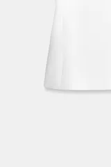 Chaleco negro sin mangas, de cuello redondo y corte entallado con peplum sutil. Presenta pinzas verticales en el frente y falsos bolsillos de vivo a la altura de la cadera.