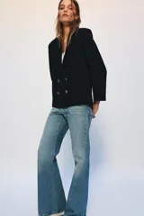 Jeans de tiro bajo con corte flare y diseño de cinco bolsillos. Presentan un acabado con efecto lavado y bajo evasé, con cierre frontal de cremallera y botón.