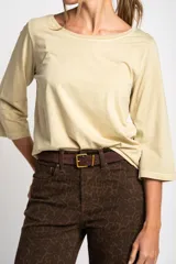 Remera de algodón peinado en color beige, con cuello redondo y mangas tres cuartos. Presenta un acabado lavado que le otorga un aspecto suave y confortable.