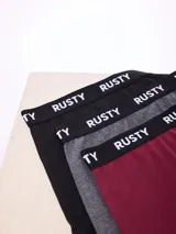 Pack de tres boxers Rusty modelo Tory en colores negro, gris melange y bordó, con cintura elástica con el nombre de la marca impreso en blanco.