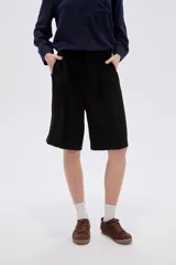 Short ancho de poliéster color negro, de tiro alto y diseño sastrero con pinzas en el frente.