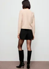 Cardigan de punto de corte recto con cuello redondo, manga larga y cierre frontal con botones dorados.
