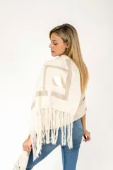 Chal o pashmina color crema con detalles de cintas tejidas en tonos beige y flecos largos.