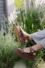 Sandalias de plataforma color negro, con diseño de dos tiras anchas en el empeine y cierre con velcro en el tobillo. Presentan una suela de plataforma alta y liviana.