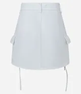 Minifalda blanca de sarga con bolsillos cargo laterales y lazo ajustable.