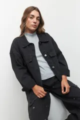 Polera de tejido de punto color gris claro, de cuello alto y corte ajustado.