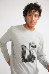 Remera de manga larga color gris melange, con cuello redondo y estampado gráfico en blanco y negro de la ciudad de Nueva York en el frente.