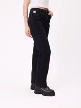 Jean de corte recto con costuras verticales decorativas en el frente, tiro medio y cierre frontal con botón metálico.