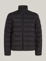 Campera acolchada negra de nailon con aislamiento térmico y acabado repelente al agua. Tiene cuello alto, cierre de cremallera, dos bolsillos delanteros y parche engomado del logo de Tommy Hilfiger en la manga.