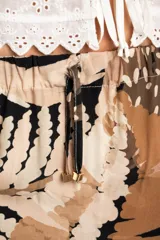 Falda larga con estampado de hojas en tonos beige, marrón y negro, con cintura elastizada y cordón ajustable.