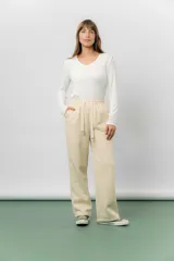 Pantalón deportivo de corte wide leg con caída relajada. Presenta cintura elastizada con cordón ajustable, bolsillos laterales y un interior frizado para mayor abrigo.