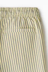 Short de baño de sirsaca color amarillo con rayas verticales oscuras, cintura elástica con cordón de ajuste y bolsillos laterales.