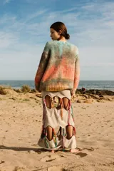 Sweater tejido a mano de lana merino, con cuello a la base y puños. Diseño a rayas horizontales en tonos celeste, marrón, naranja y amarillo.